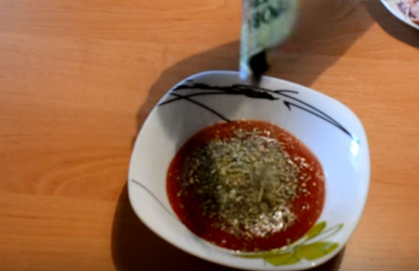 У томатний соус додаємо спеції і змащуємо коржик